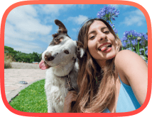 Mixed breed dog and lady sitting next to each other with green outdoor background after completing dog obedience program