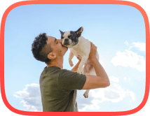 Man holding a french bulldog in his arms excited after learning new dog commands