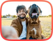 Man with a large breed dog sitting in a farm field with resolved dog aggression issue