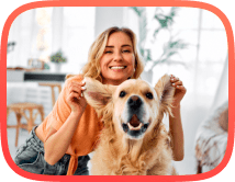 Happy blonde lady with a golden retriever in a living room after fixing dog aggression and dog reactivity issues